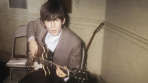 Young Keith Richards practicing guitar in a small room